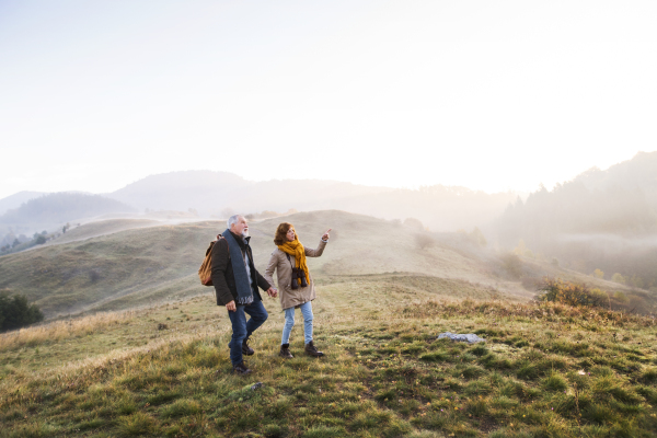 Active senior couple on a walk in a beautiful autumn nature.
