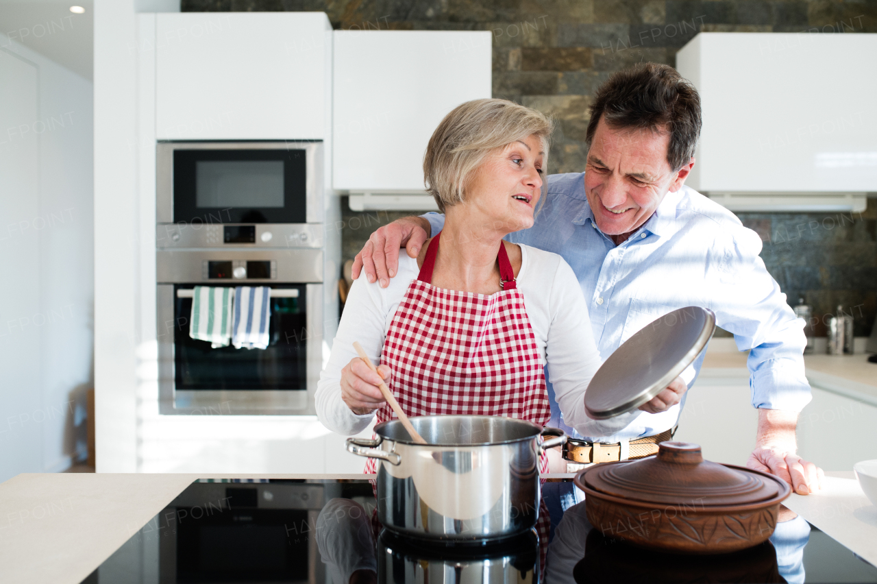 Senior woman and man in the kitchen cooking together.
