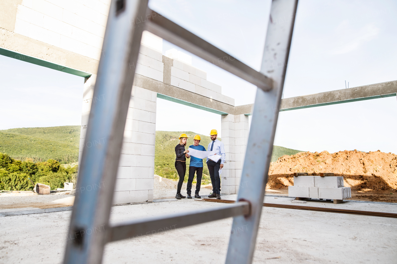 Architect, civil engineer and worker looking at plans and blueprints, discussing issues at the construction site.