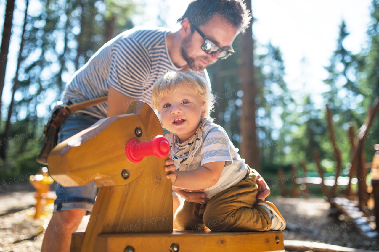 Young father with cute little boy on the playground.