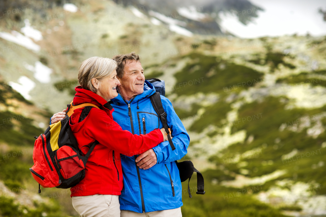 Beautiful senior couple of tourists in the mountains together, spring time.