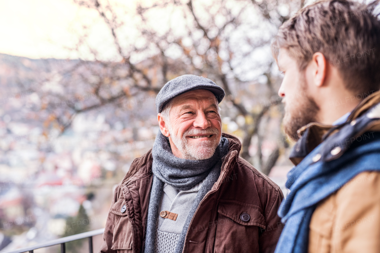 Senior father and his young son on a walk in town.