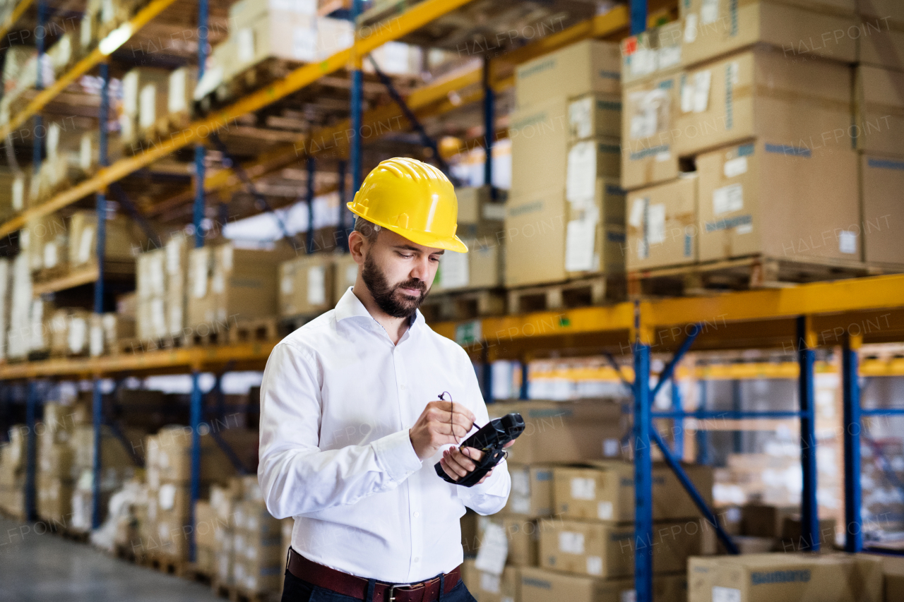 Warehouse worker or supervisor with barcode scanner. A mobile handheld PC with barcode scanner.