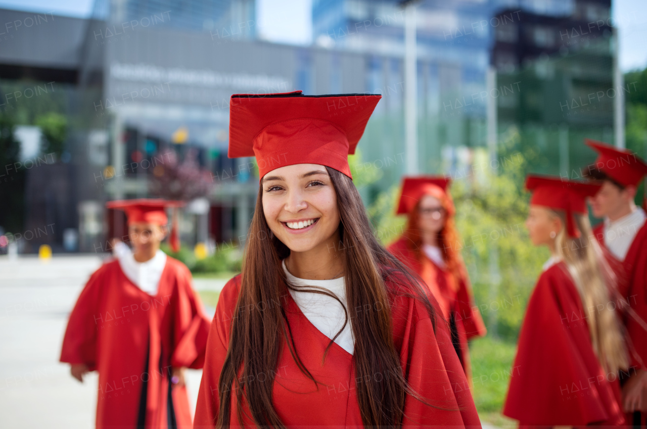 A portrait of cheerful university student celebrating outdoors, graduation concept.