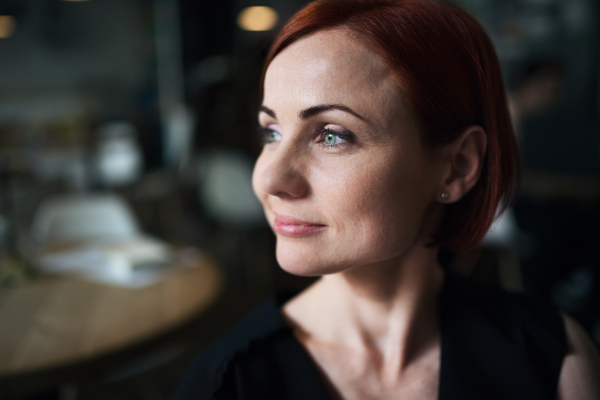 Close-up portrait of attractive woman sitting in a cafe. Copy space.