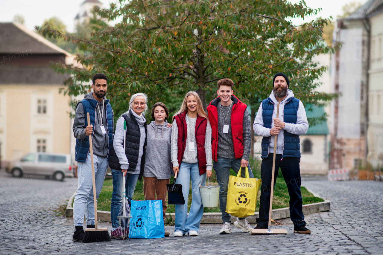 A group of happy volunteers looking at camera, ready to clean up street, community service concept