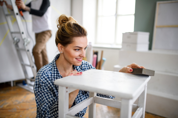 Happy mid adults couple renovating furniture indoors at home, relocation and diy concept.