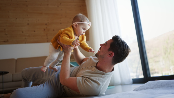 A young father enjoying time together with baby girl at home.
