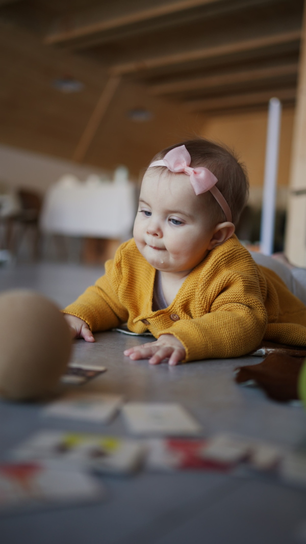 A vertical footage of little baby lying on floor and playing.