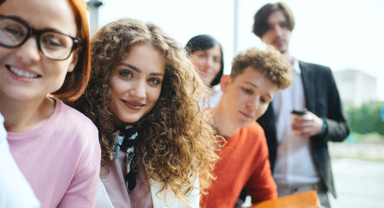 A portrait of businesspeople entrepreneurs outdoors indoors in office, looking at camera.