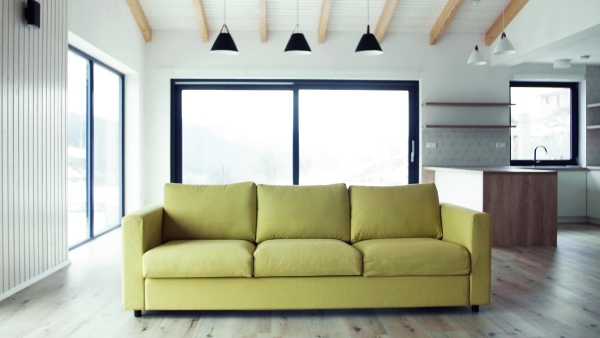 A yellow sofa in modern interior of a house or flat in new home. A moving in new home concept.