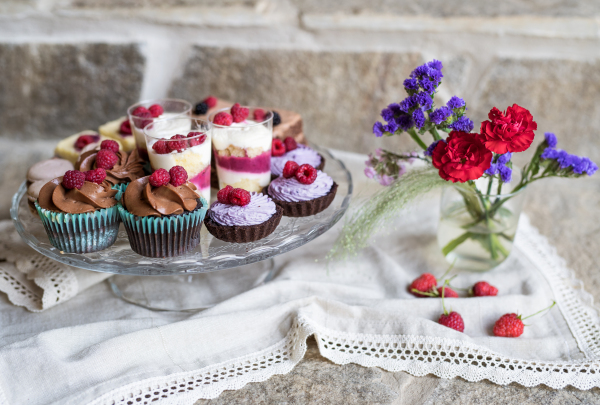 A selection of colorful and delicious cake desserts on tray on table.
