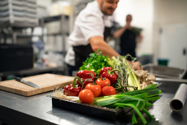 Fresh ripe vegetables prepared for cutting in a commercial kitchen.