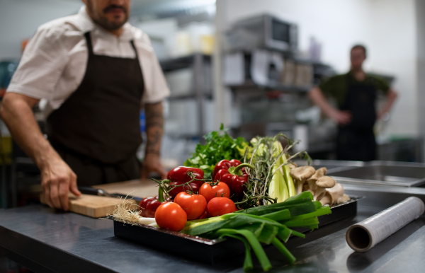 Fresh ripe vegetables prepared for cutting in a commercial kitchen.