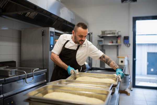 A professional chef preparing meal indoors in restaurant kitchen.