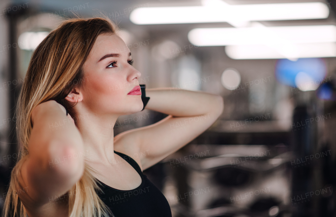 A portrait of a beautiful young girl or woman standing in a gym. Copy space.