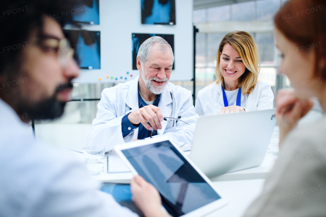 A group of doctors looking at X-ray on medical conference, discussing issues.