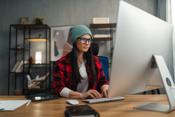 A female video editor works indoors in creative office studio.