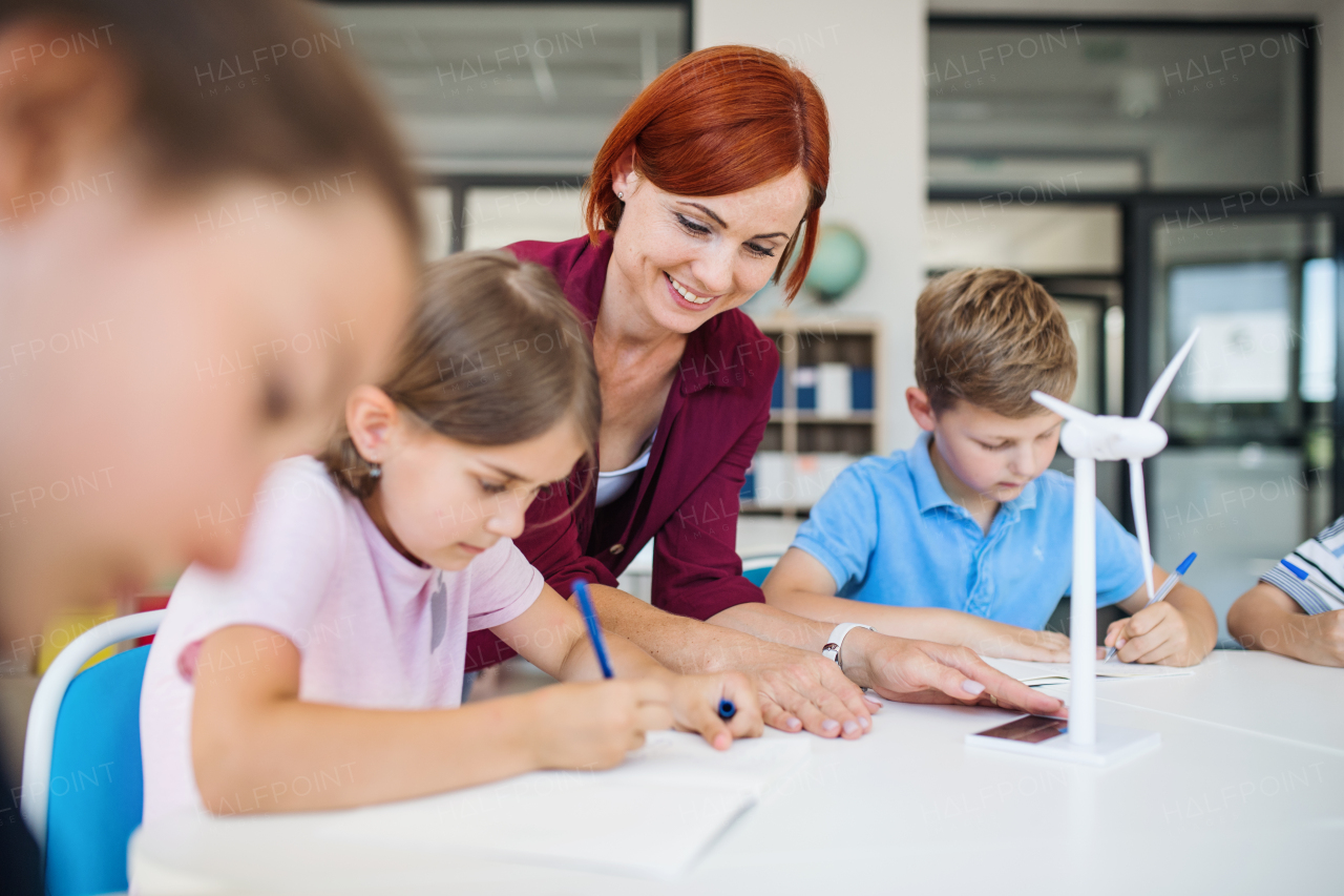 A group of small school kids with teacher in science class learning about environment.
