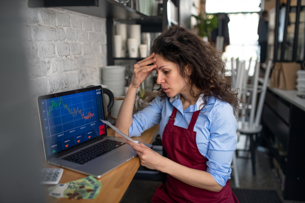 A frustrated coffee shop manager discussing issues with waitress in cafe, small business and new normal concept.