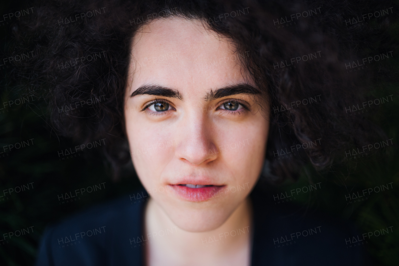 A close-up portrait of happy young woman with curly hair.