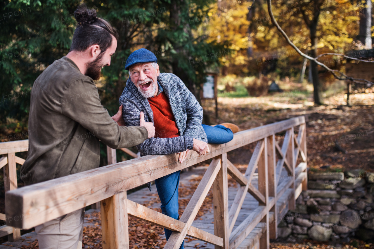Senior father and his young son walking in nature, having fun.