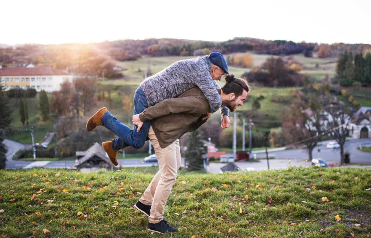 Senior father and his young son walking in nature, having fun.