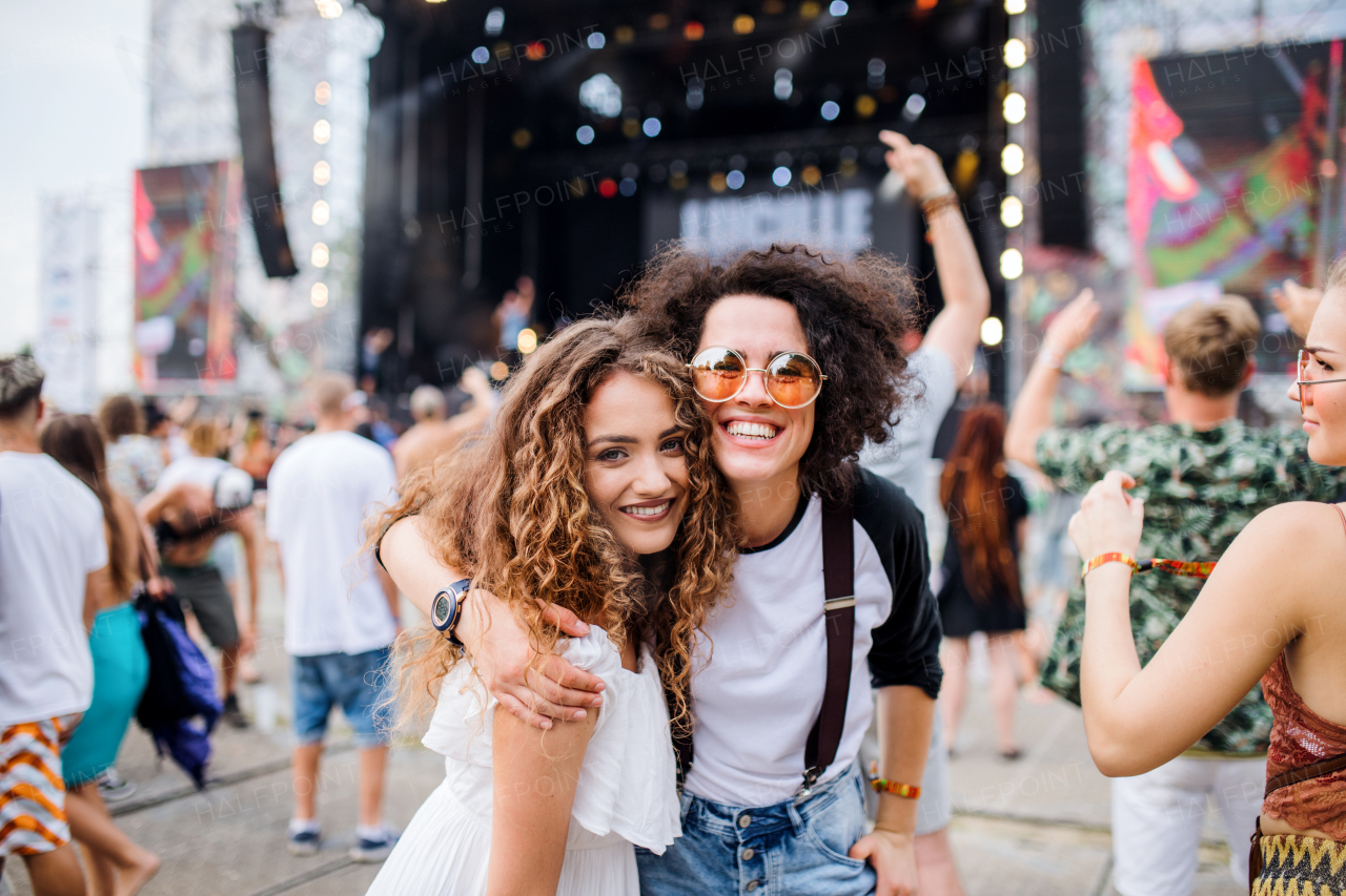 Young girl friends at summer festival, posing for photograph. Copy space.