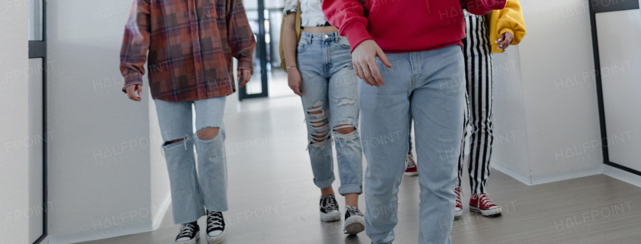 Young high school students walking in a corridor at school, back to school concept.