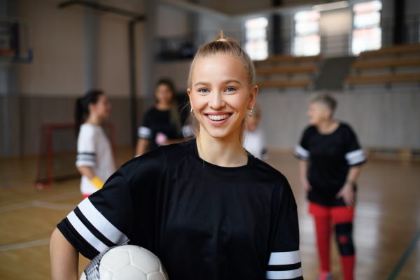 Young woman posing with a basketball ball before womans match.