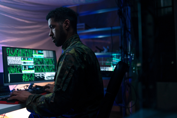 An American hacker in military unifrorm on dark web, cyberwar concept.