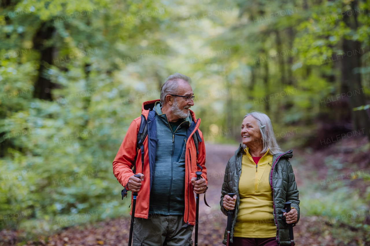 Happy senior couple hiking in autumn nature.