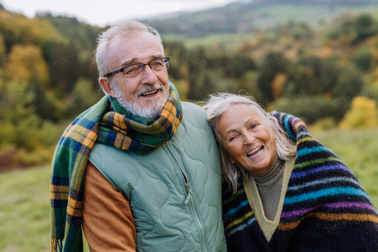 Senior couple in love huging each other in autumn forest.