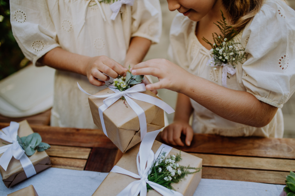 Little girls preparing gift for bride at a wedding garden party.