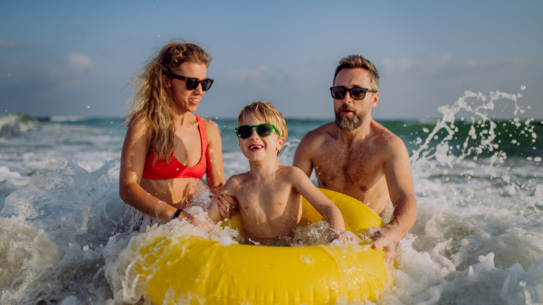 Happy family with little son enjoying time in the sea in exotic country.