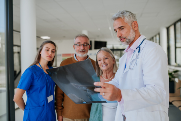 Doctor showing x-ray image to patients, explaining a diagnosis.