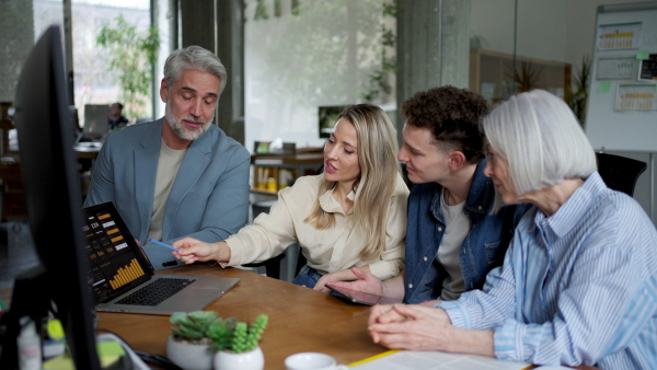 Businessman giving a presentation in a business meeting. Young colleagues and manager having casual discussion during meeting, workshop in office.