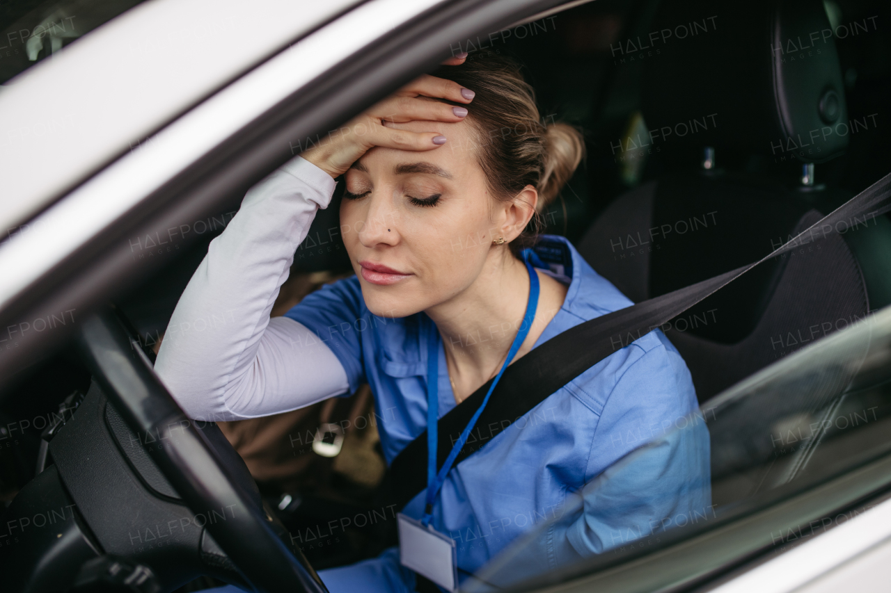 Nurse crying in car, going home after hard work day in hospital. Doctor feeling exhausted, frustrated, sad and angry. Work-life balance of healthcare worker.