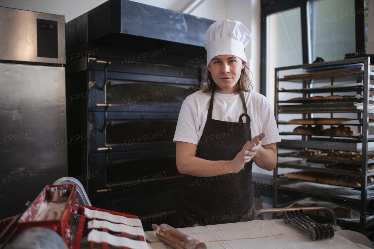 Young baker preparing pastries in a bakery.