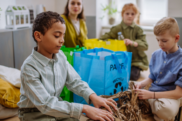 Children separating rubish in to a bins.