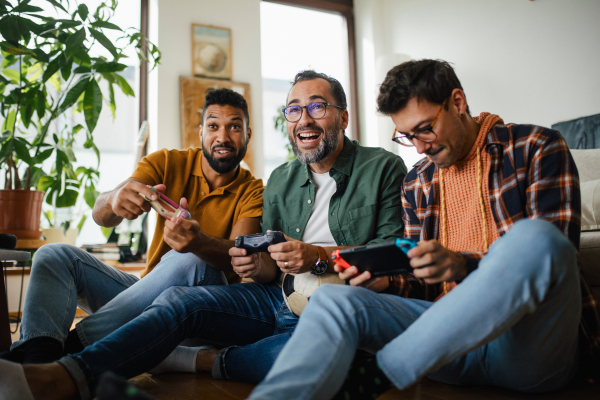 Best friends playing together on video game console, competing. Concept of male friendship, bromance.