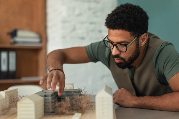 Young architect hard working on design of new house, building. Designing of architectural objects.