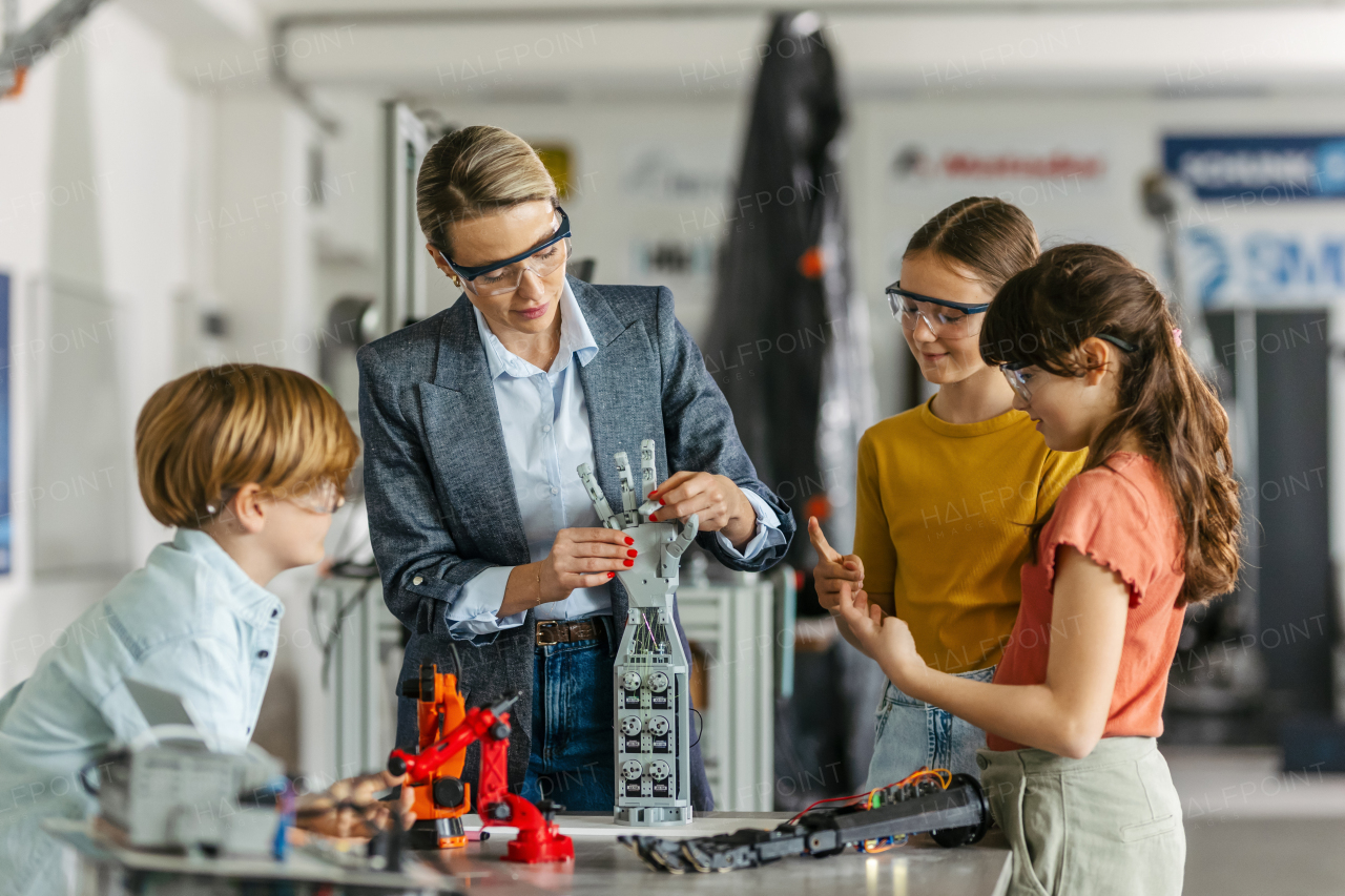 Children learning robotics in Elementary school. Young students building robot in after school robotics club. Field trip to real robotics laboratory.