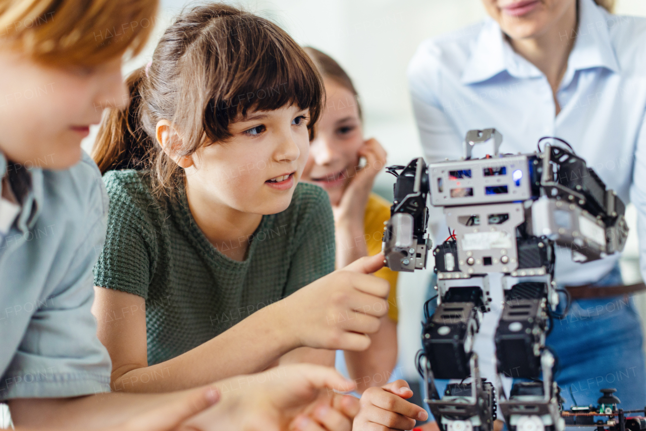 Children learning robotics in Elementary school. Young students building robot in after school robotics club. Field trip to real robotics laboratory.