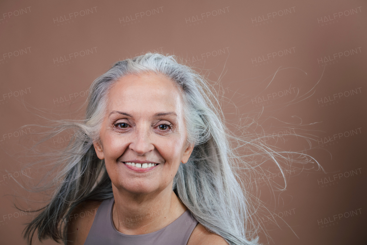 Portrait of smiling senior woman in a studio.
