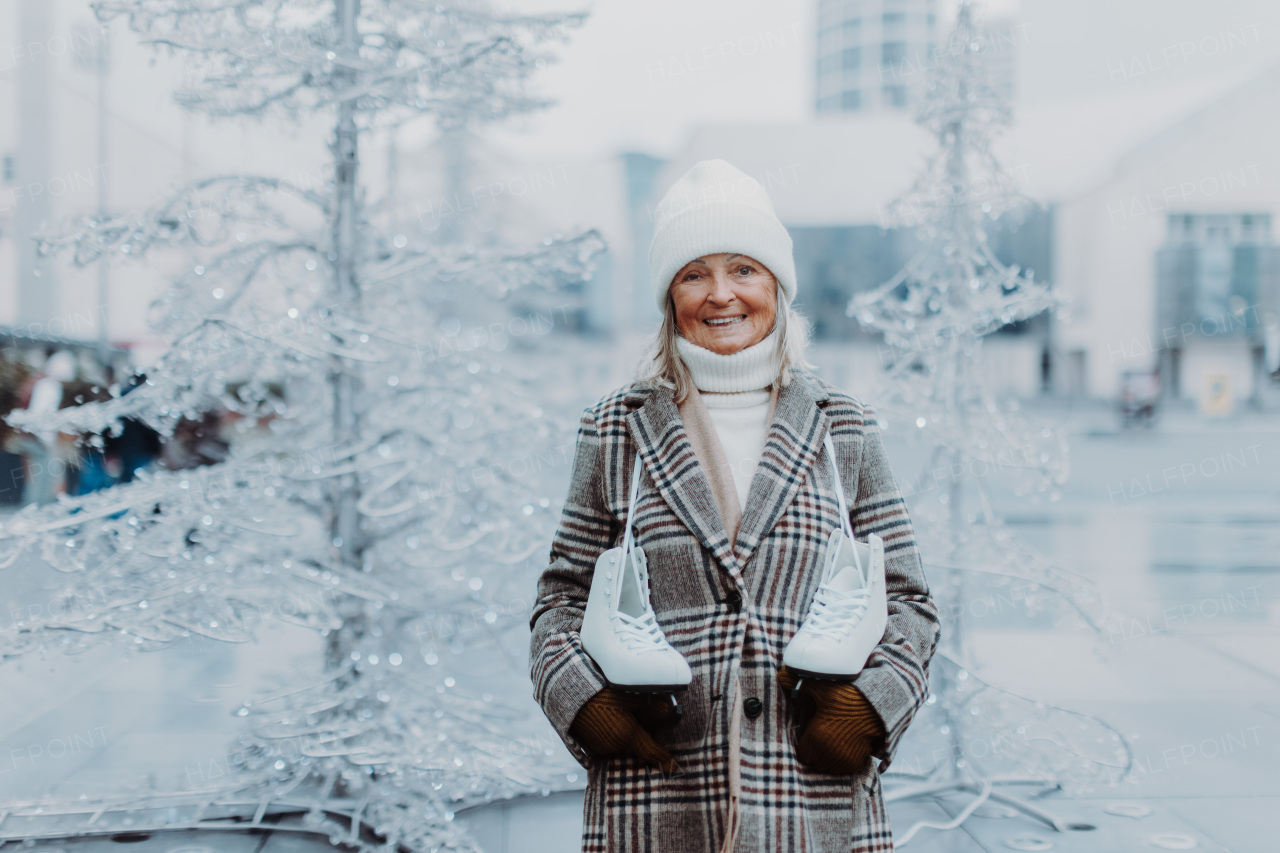 Portrait of happy senior woman in winter at an outdoor ice skating rink.