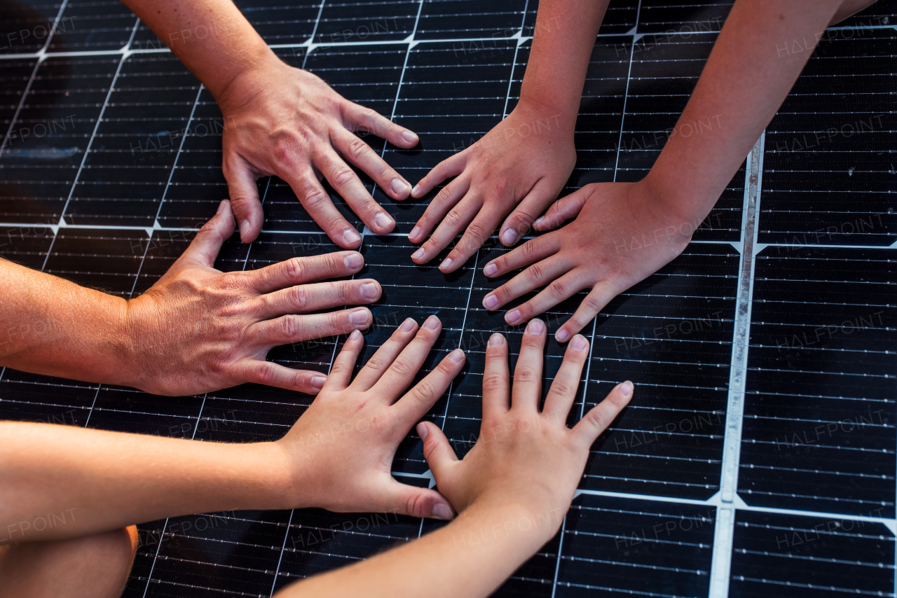 Close up of hands on solar panel. Rooftop solar or photovoltaic system. Sustainable future for next generation.