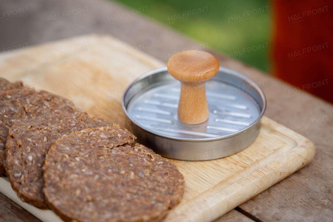 Close up of preparing meat for hamburgers. Using burger patty press to shape groud meat