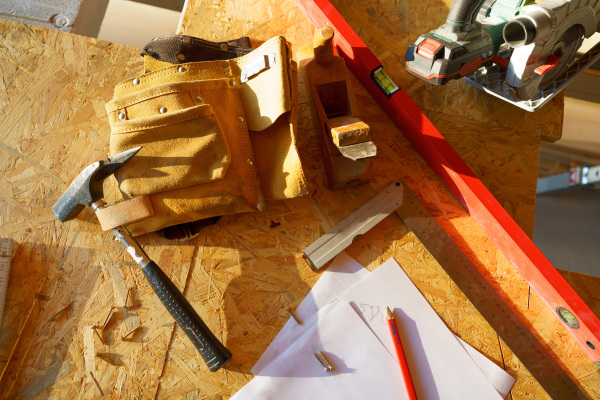 Close up of a construction tools inside of unfinished wooden house.