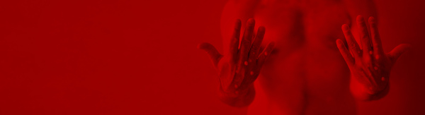 A male hands affected by blistering rash because of monkeypox infection on red background